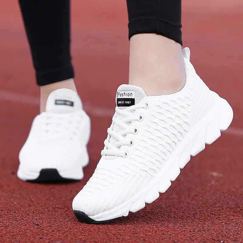 Women's fly knit running shoes in black, pink, or white colours, showing the woven upper and durable outsole.