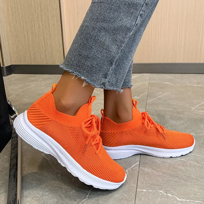 Women's creamy white Flyknit running shoes with mesh lining and low-top design on a rubber sole