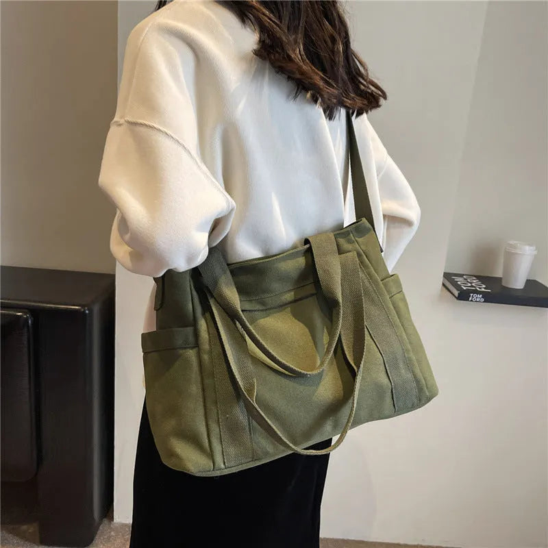 Large polyester canvas shoulder tote bag in solid colour with outer pocket and shoulder strap