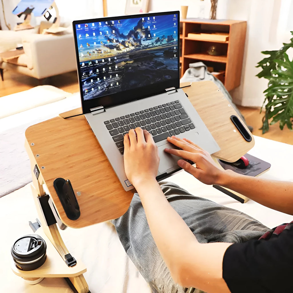 Wooden folding computer table on bed showing adjustable angle mechanism in white maple finish