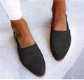 A pair of flat buckle sandals with a pointed toe, shown in one of the available colours.