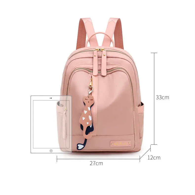 Black nylon casual travel backpack with double shoulder straps, external pockets, and a soft handle on a solid background.