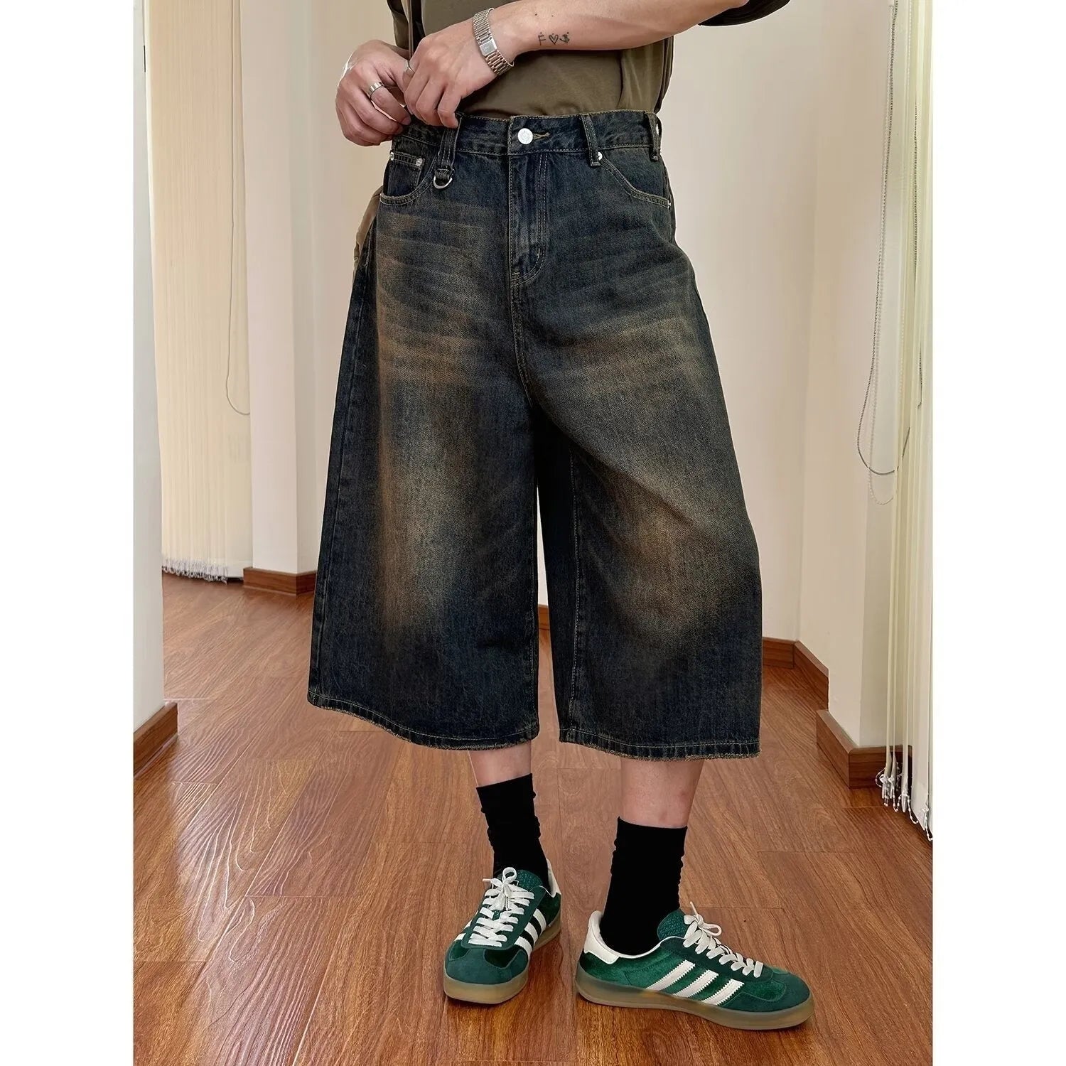 Men's loose fit jeans shorts in blue denim with a straight leg, shown on a model.