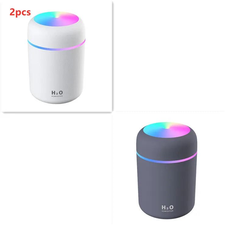 Pink USB mini humidifier with LED lights and water tank on desk