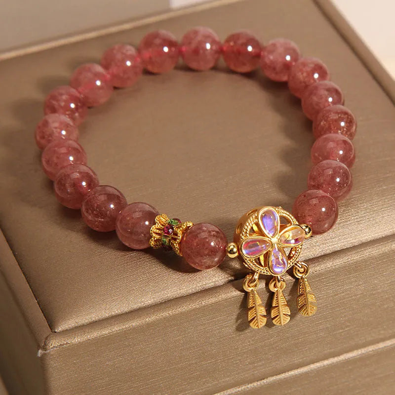 Women's bracelet with strawberry quartz beads and crystal accents featuring four-leaf dream catcher pendant