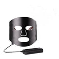 Black and white LED phototherapy face mask with controller showing seven colour light modes