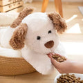 Plush toy lying dog doll in brown faux fur, 35cm height, lying on a soft surface
