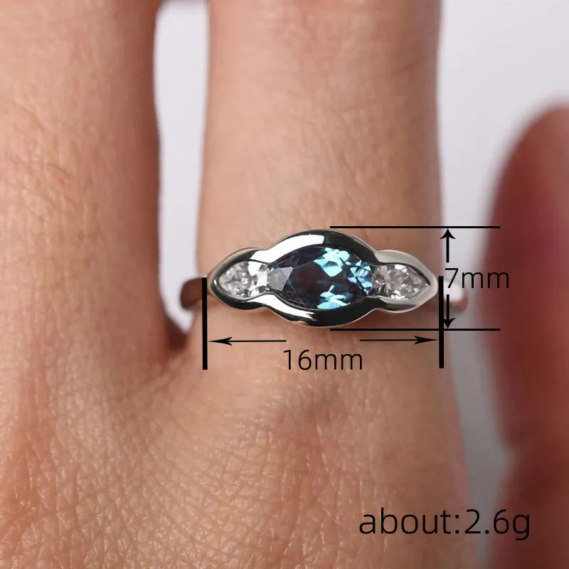 Geometric ellipse women's ring with a central zircon stone and white gold plating.