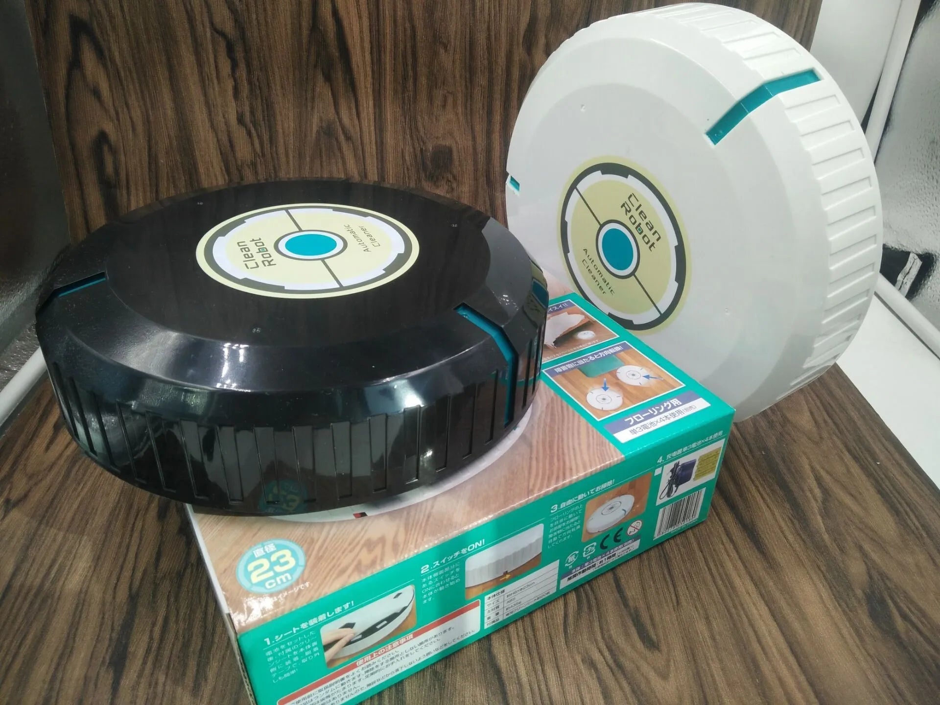 Black or pure white automatic floor sweeping robot with 23cm diameter on wooden floor
