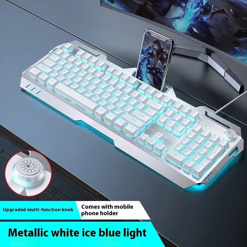 Aluminium gaming keyboard with volume knob, shown in metal grey with RGB lighting alongside optional macro mouse and headset.