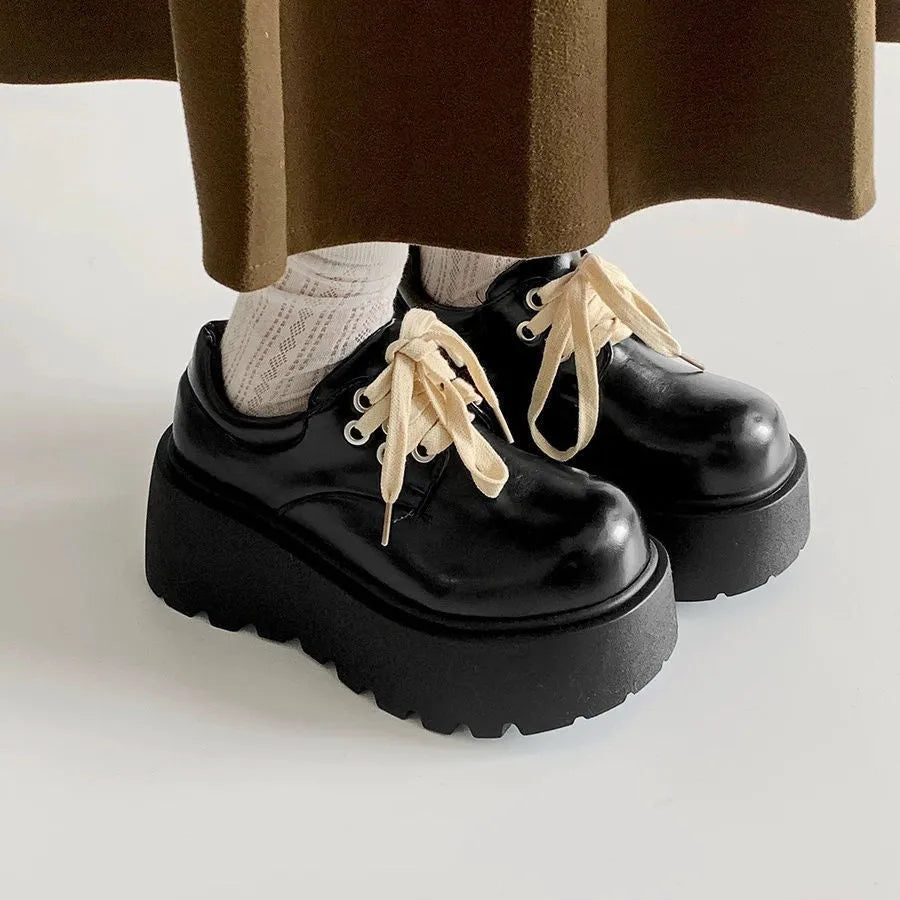 Matte black women's high-heel shoes with a thick rubber sole and lace-up buckle.