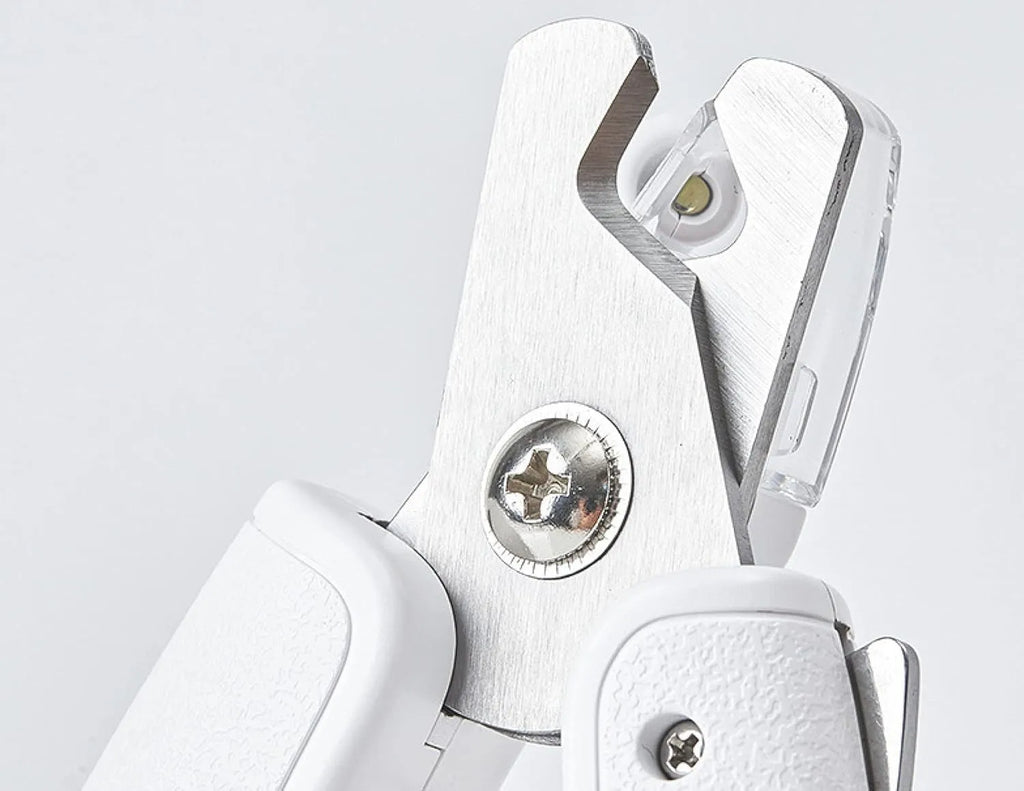 White pet nail clippers with LED light, transparent anti-splash baffle, and triangular steel blades for cats and dogs