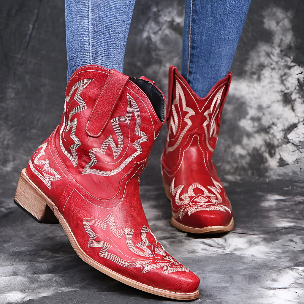Blue women's cowboy ankle boots with embroidery, a pointed toe, and a low wedge heel.