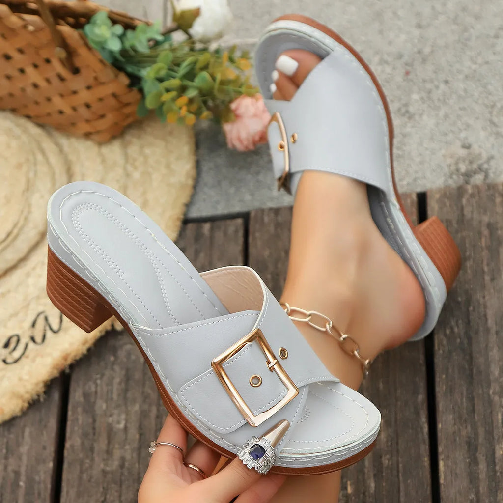 Women's black retro style slippers with a chunky heel and silver metal buckle on a rubber sole.