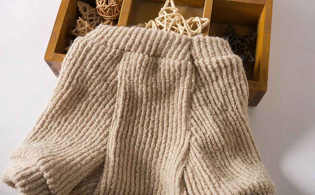 Brown cloth pullover dog sweater on a small breed dog.