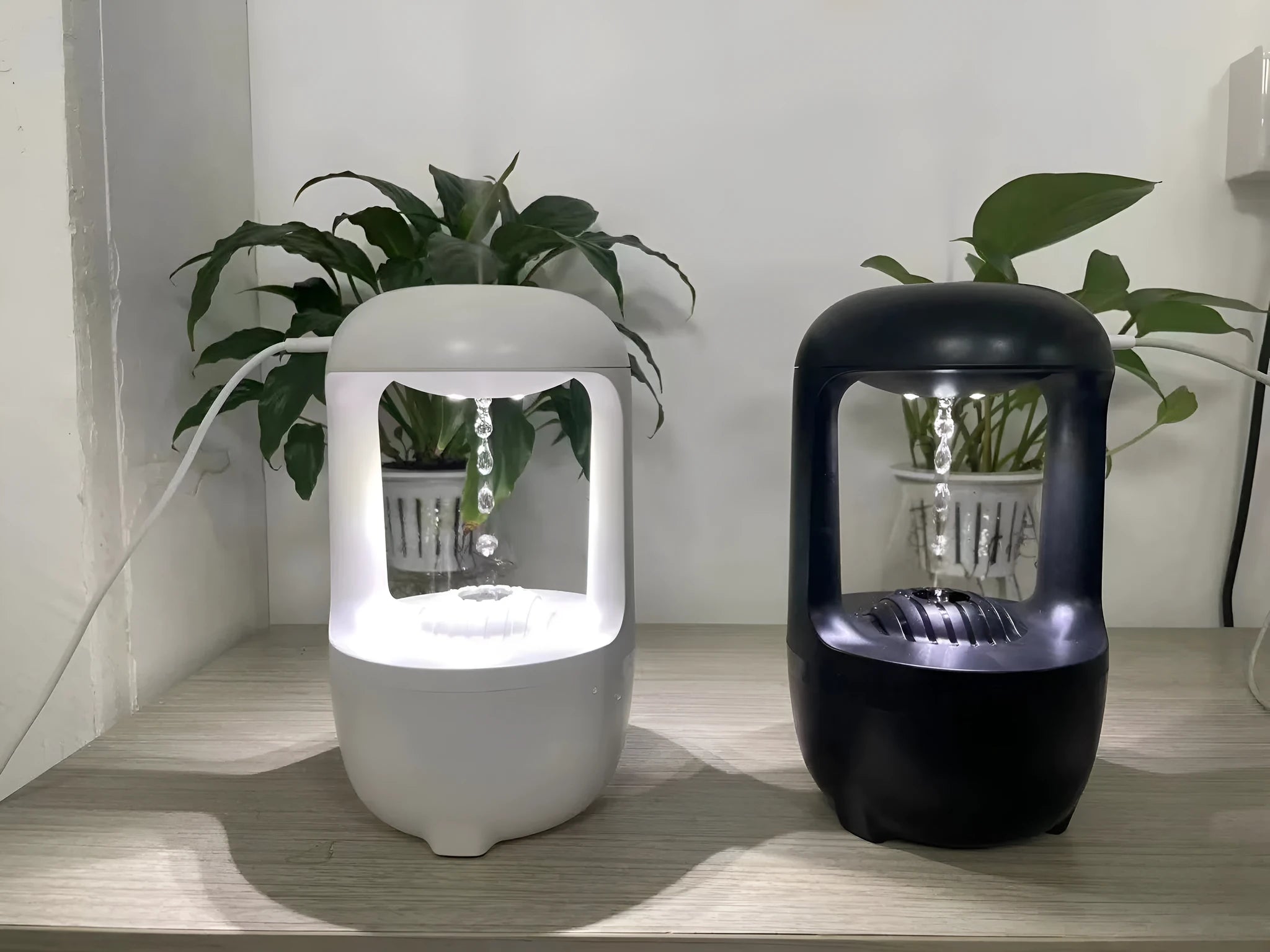 White anti-gravity humidifier with water droplet effect on a desk next to a USB cable.
