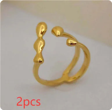 Gold or silver brass opening ring with spherical design elements on a model's finger.