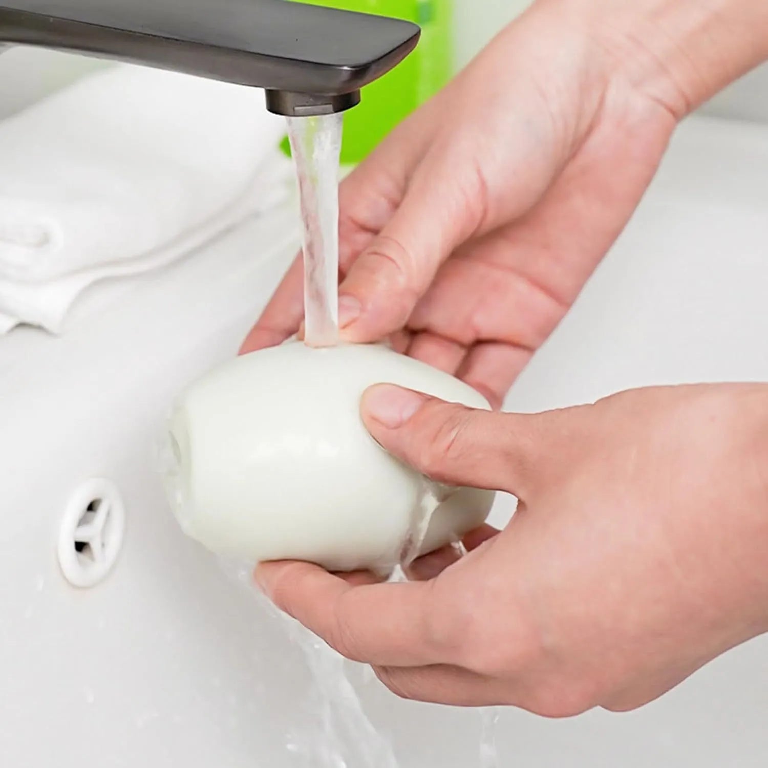 Green and white reusable gel lint roller ball for portable pet hair and lint removal.