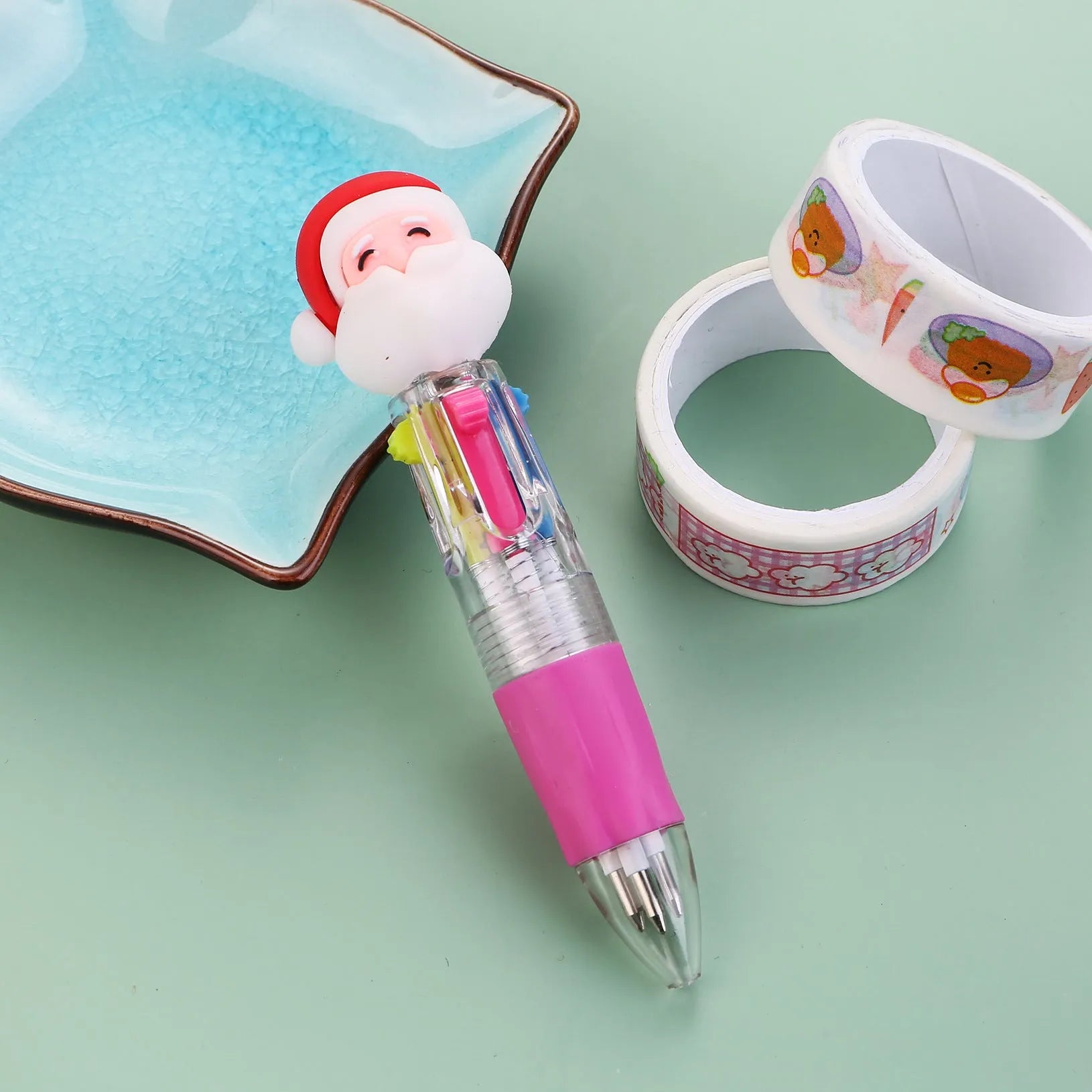 Christmas-themed ballpoint pen with press button, showing designs of snowmen, reindeer, and trees on plastic barrel.