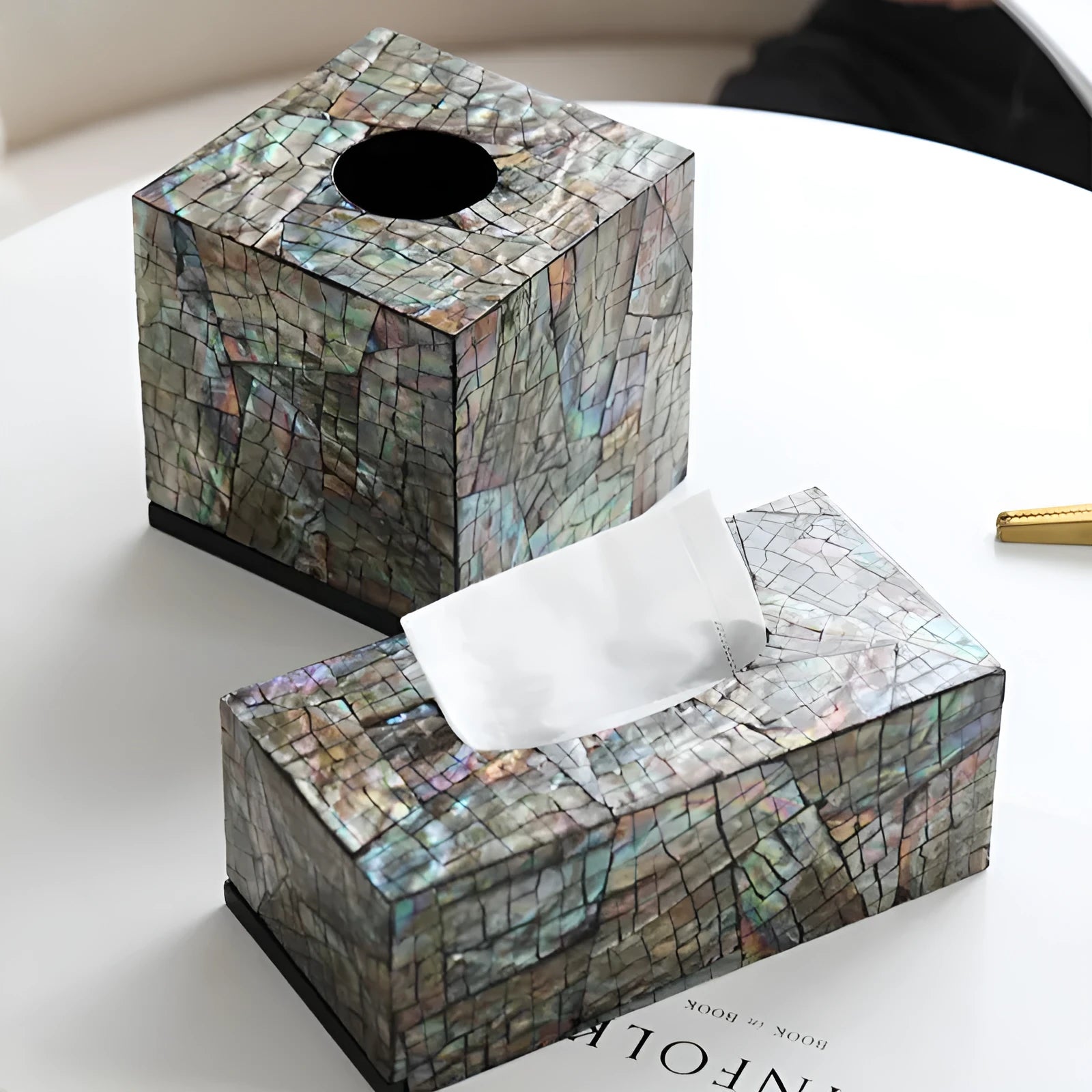 Black rectangular natural shell tissue box storage container with removable insert on a table.