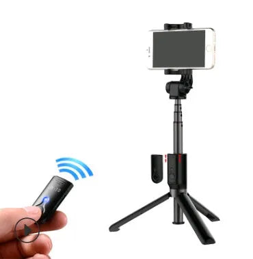 Aluminium Bluetooth selfie stick with tripod base and remote control next to a mobile phone.