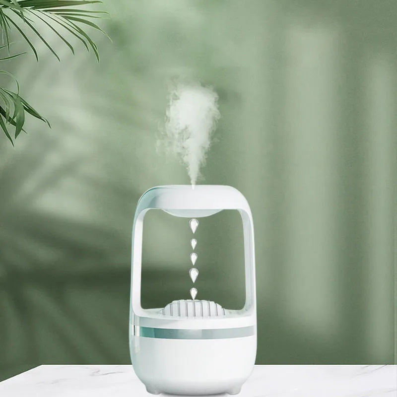 White anti-gravity humidifier with water droplet effect on a desk next to a USB cable.