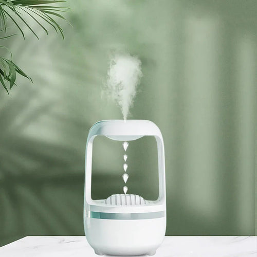 White anti-gravity humidifier with water droplet effect on a desk next to a USB cable.