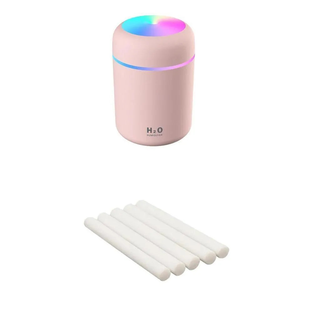 Pink USB mini humidifier with LED lights and water tank on desk