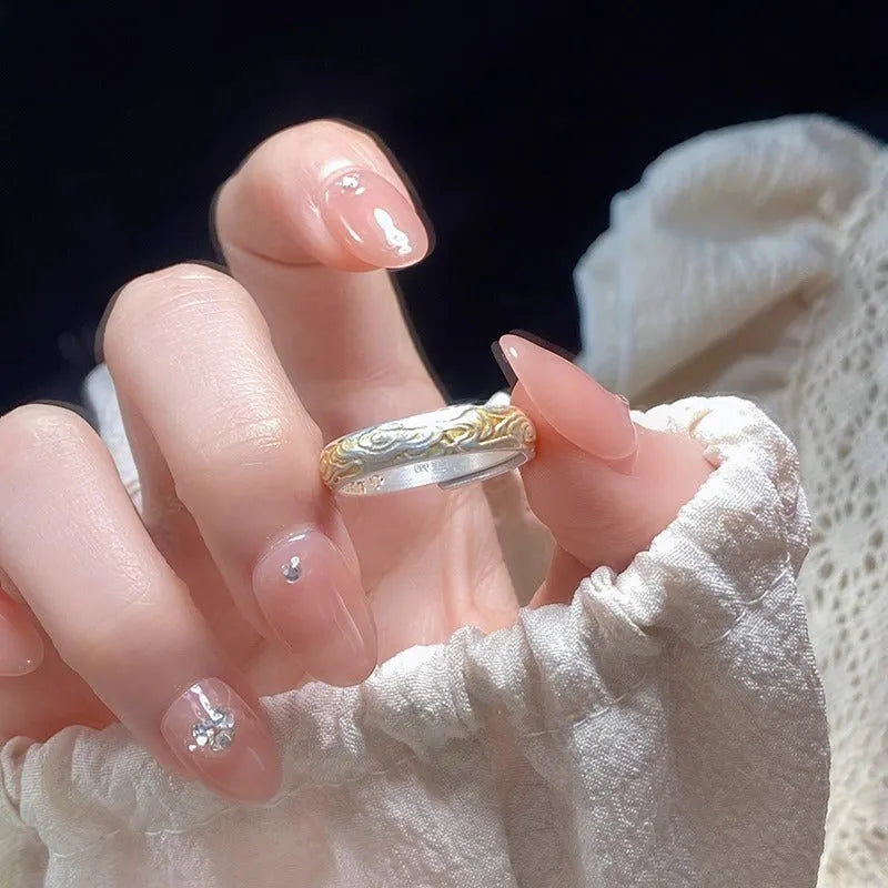Geometric xiangyun pattern open mouth ring in silver electroplated finish on white copper.