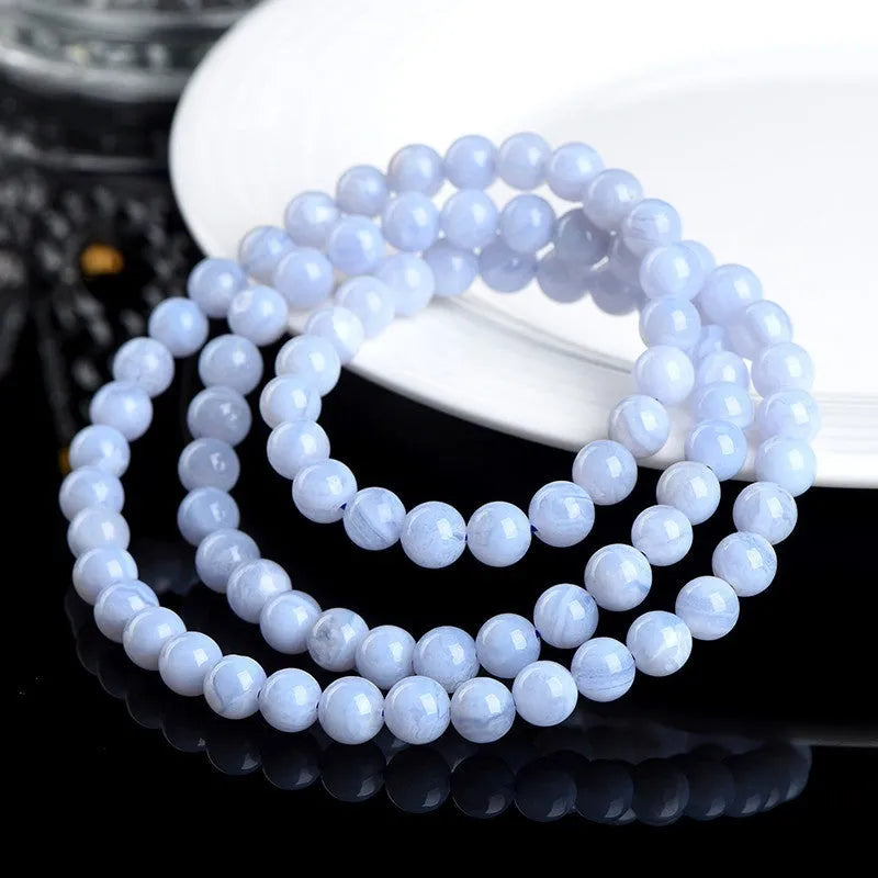 Blue agate bracelet with natural striped pattern and scattered bead design featuring Ruyi elements
