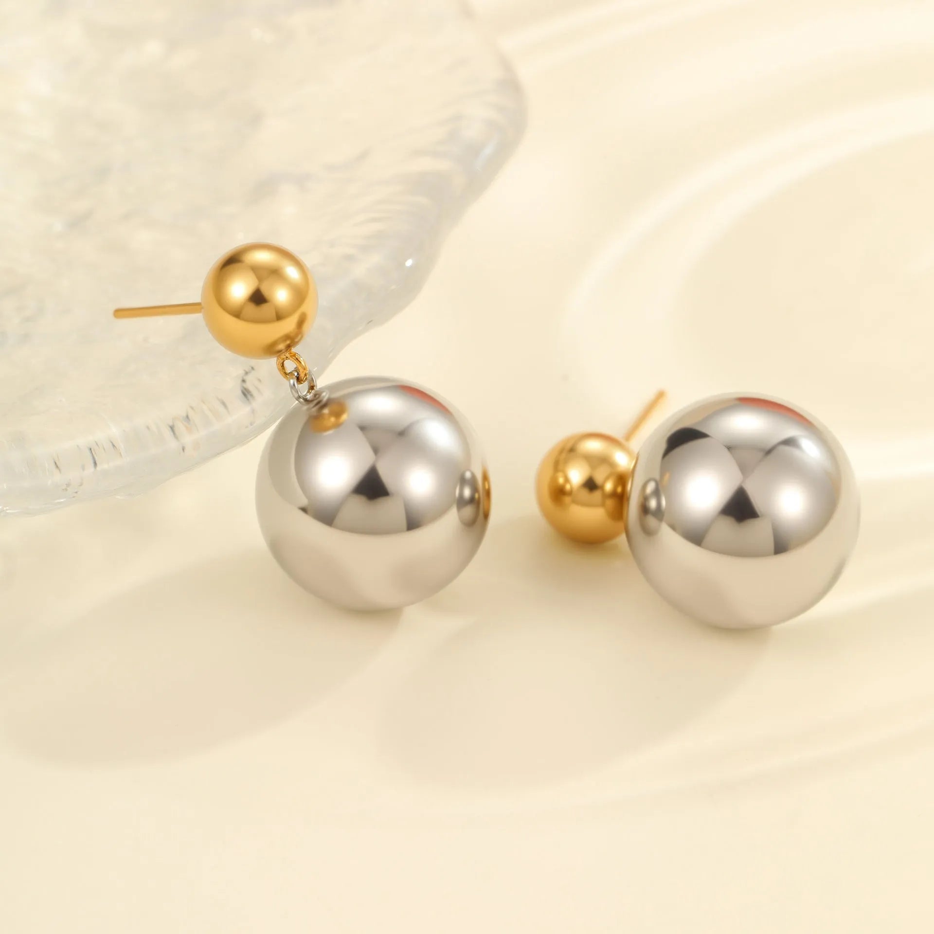 A pair of round bead stainless steel stud earrings with a colour-block geometric design.