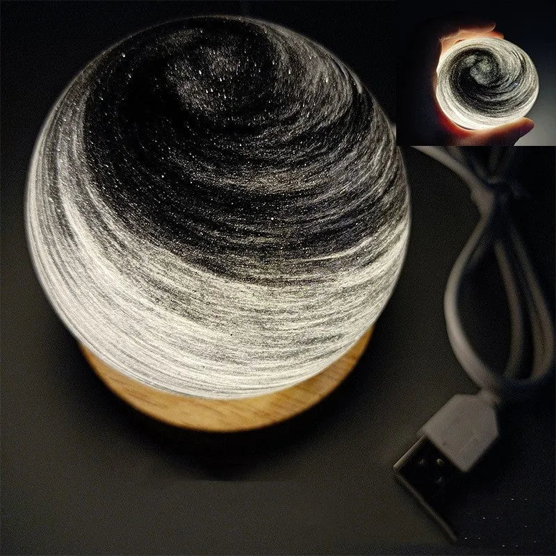 Planets themed USB night light with modern design and three-colour dimming on bedside table.