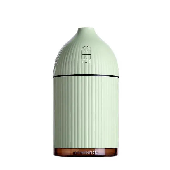 White ultrasonic aromatherapy diffuser and humidifier with LED light on a wooden surface.