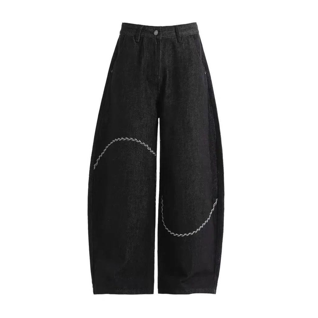 Men's black straight-leg denim trousers with a zip fly on a mid waist, shown in a casual street style.