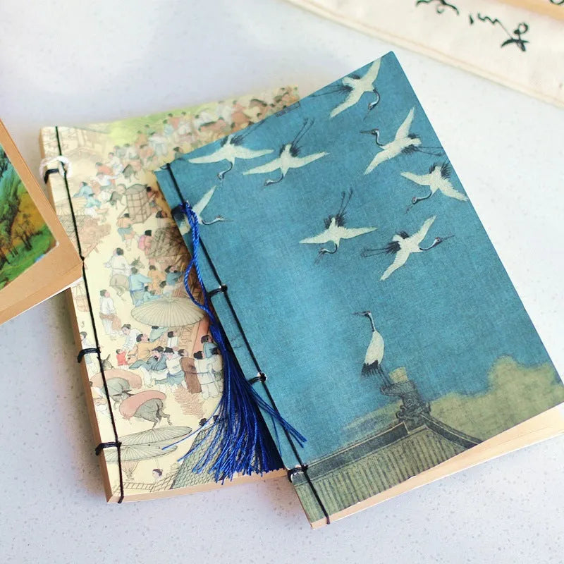 A5 antique wire-bound notebook with retro painting cover, open to show Kraft paper pages