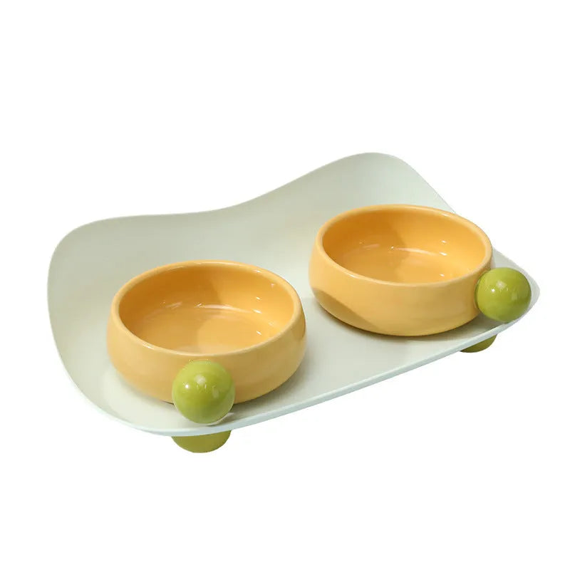 Ceramic raised pet feeding bowl set in pink with two bowls and non-slip base.