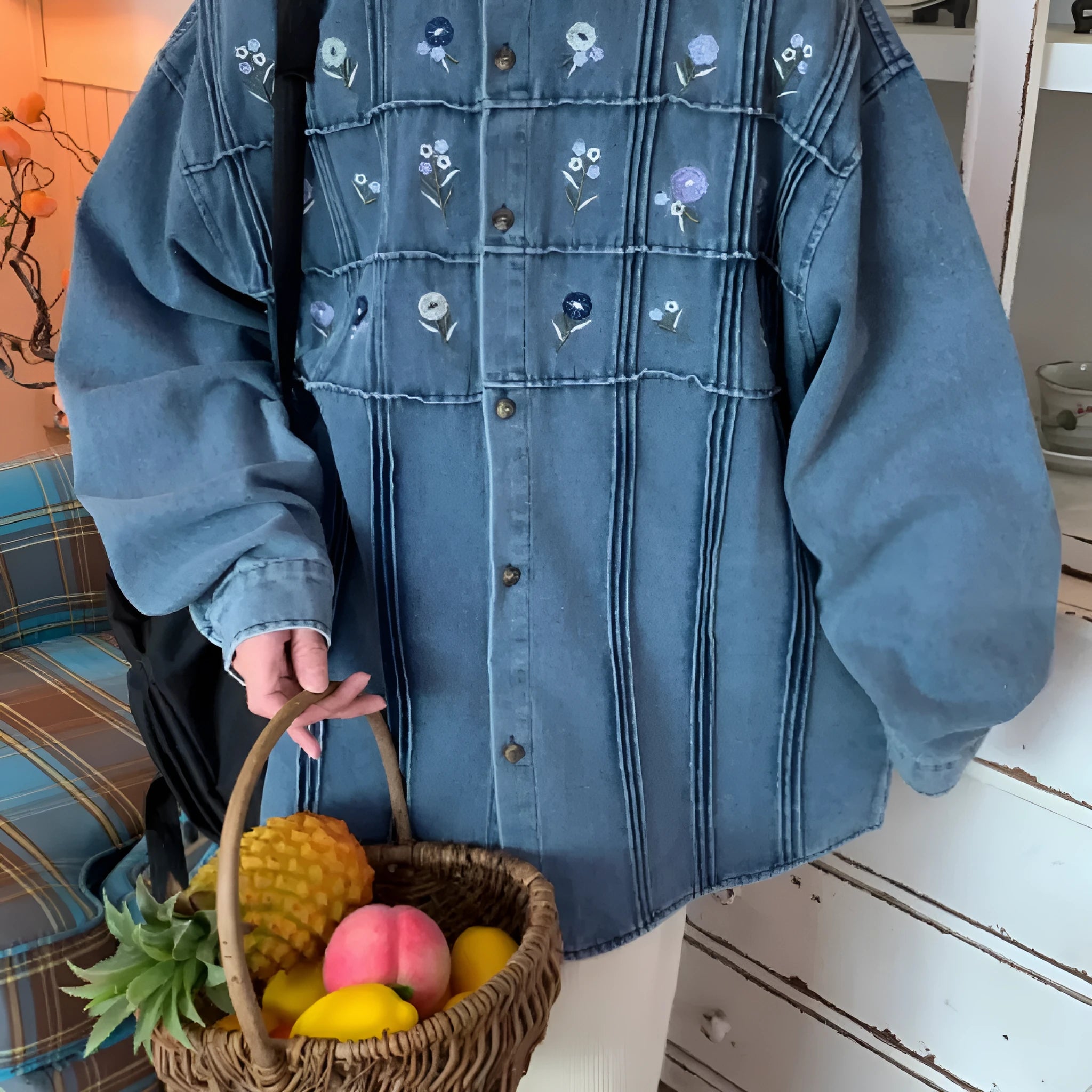 Washed blue denim long sleeve shirt with small floral pleated details on front.
