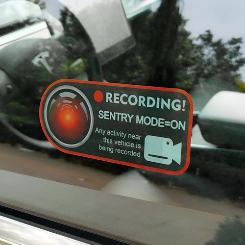 Pair of white electrostatic PVC warning stickers for Tesla car sentry mode, measuring 11 by 5 centimetres.