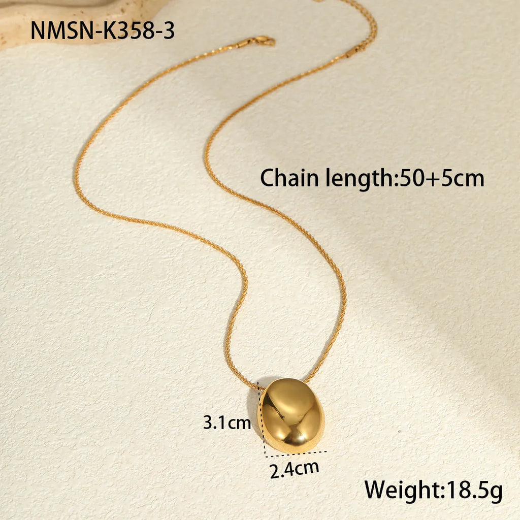 Gold geometric pendant necklace on a model, showing the adjustable chain length.