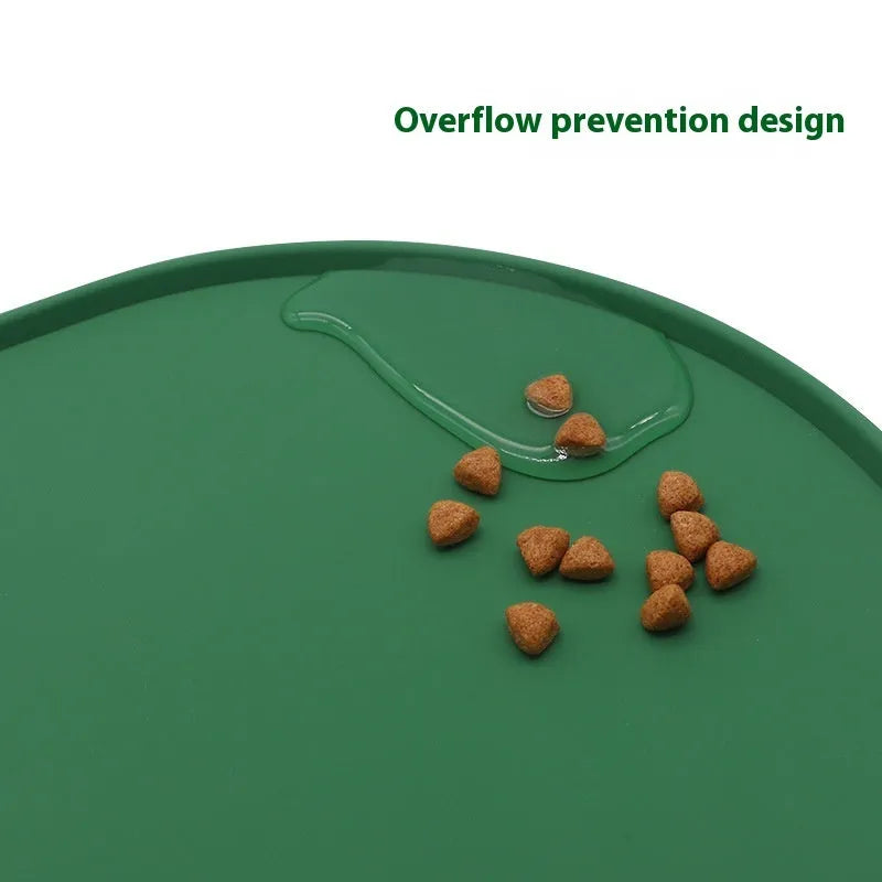 Silicone cat feeding placemat in green colour, shown under a food bowl on a wooden floor.