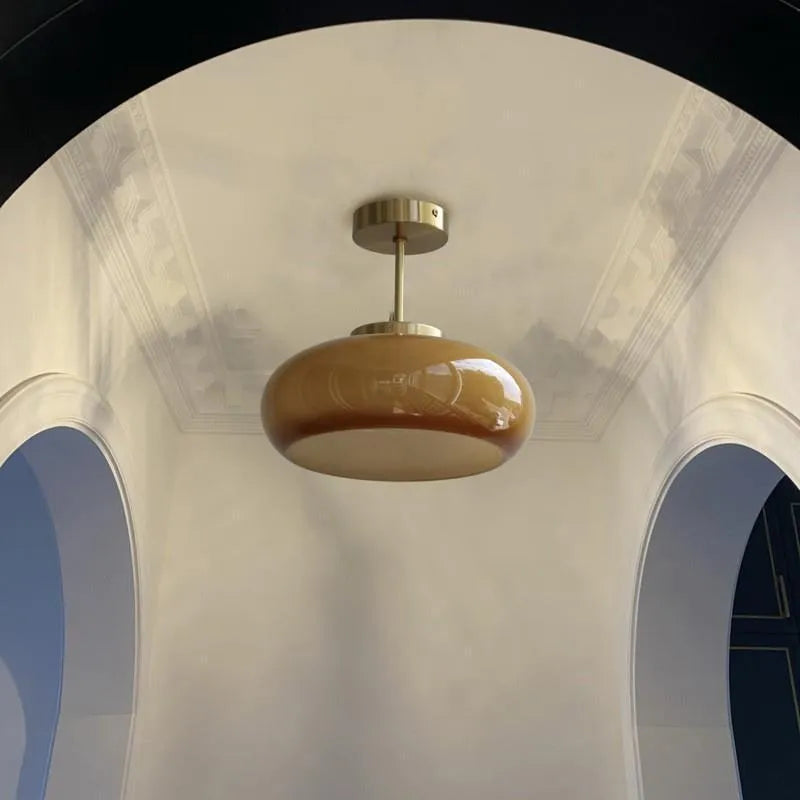 Three-headed Bauhaus pendant light with milky white glass egg tart shades hanging from a ceiling.
