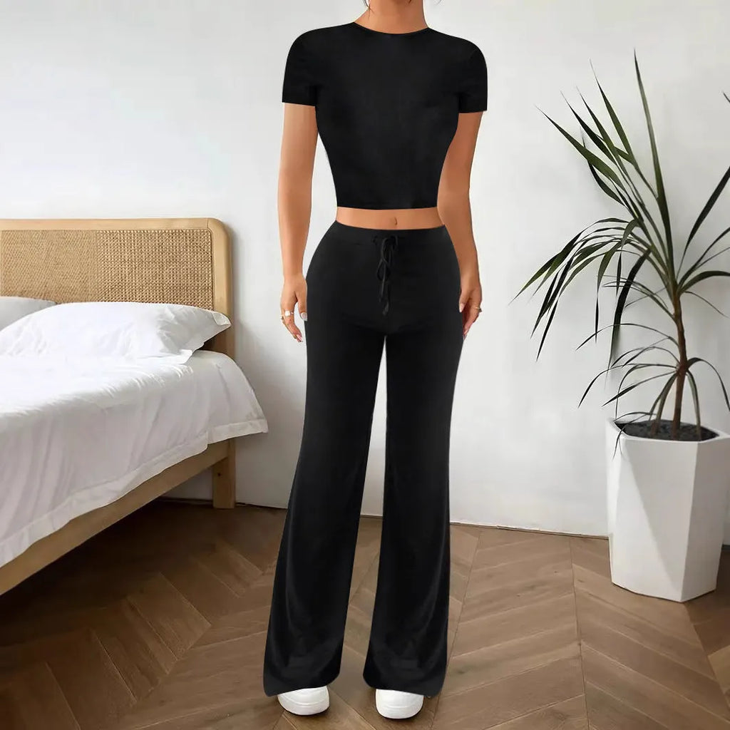 Black high-waist trousers and matching short-sleeve T-shirt co-ord set laid flat.