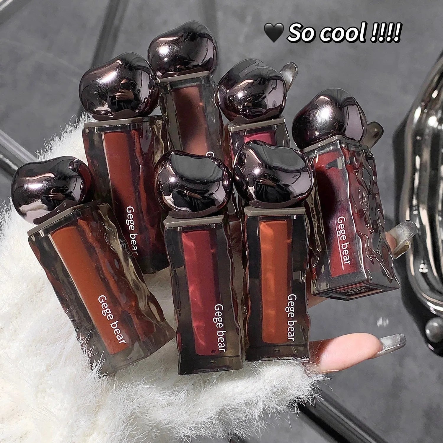 Glacier Lava Lip Lacquer lip gloss tube showcasing a high-shine, mirror finish, with visual of seven colour shade options.