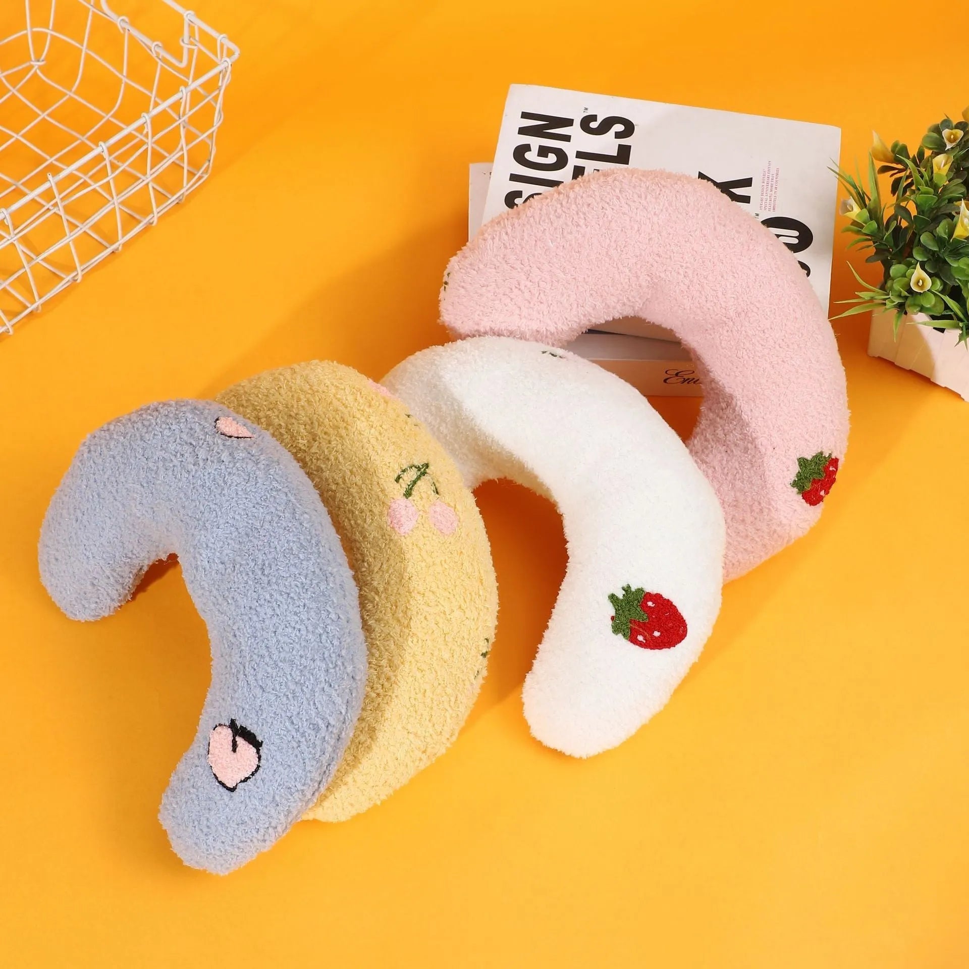 Blue U-shaped half moon cloth pillow for cats and dogs on a wooden floor.