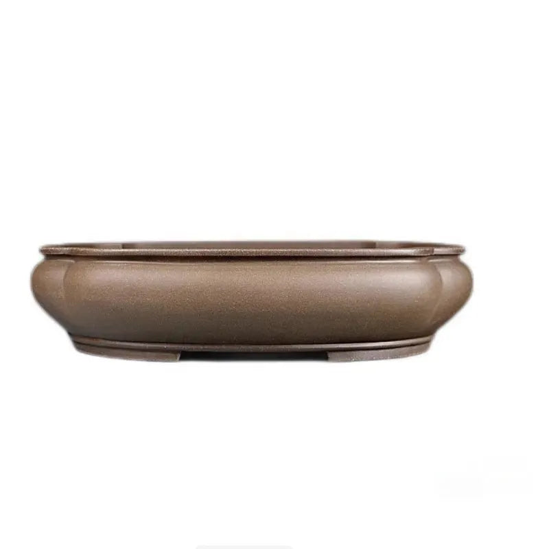 Handmade antique purple clay papaya-shaped flower pot on a wooden surface.