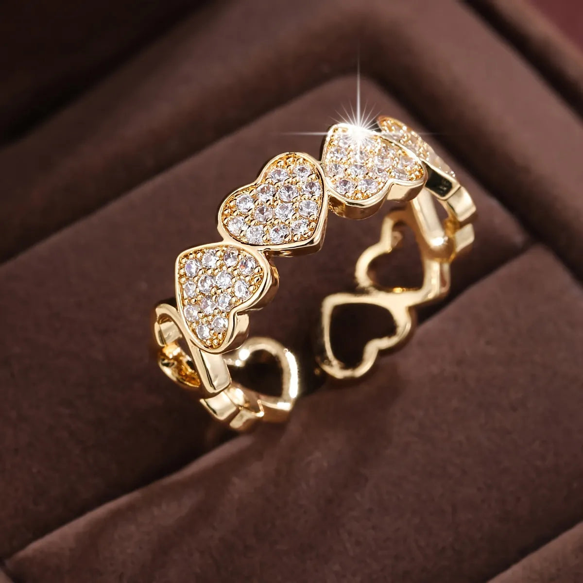 Gold copper couple ring with adjustable opening and love heart design on plain background