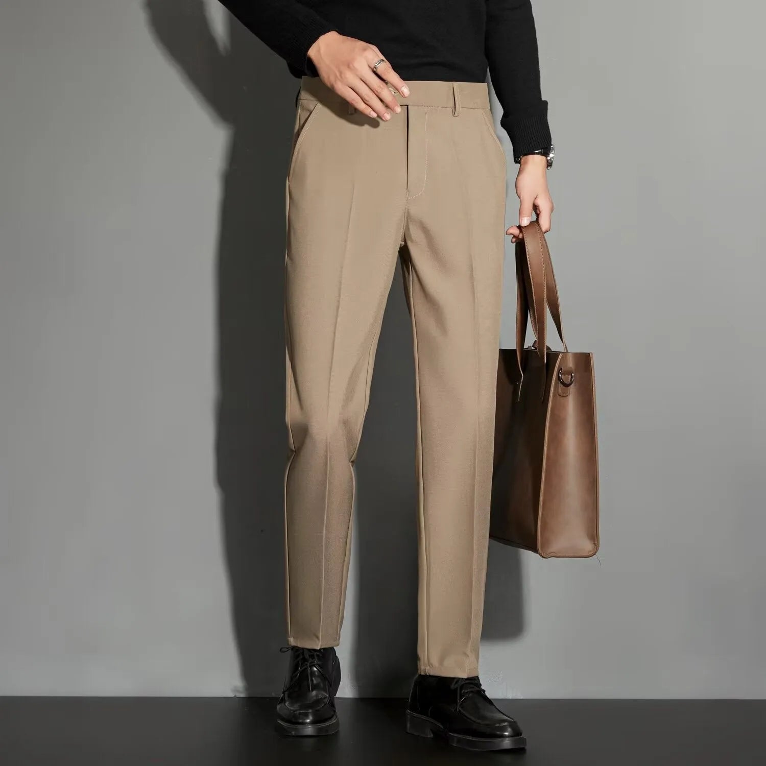 Man wearing straight leg ankle-length suit trousers in a light colour, showing the drape of the fabric.