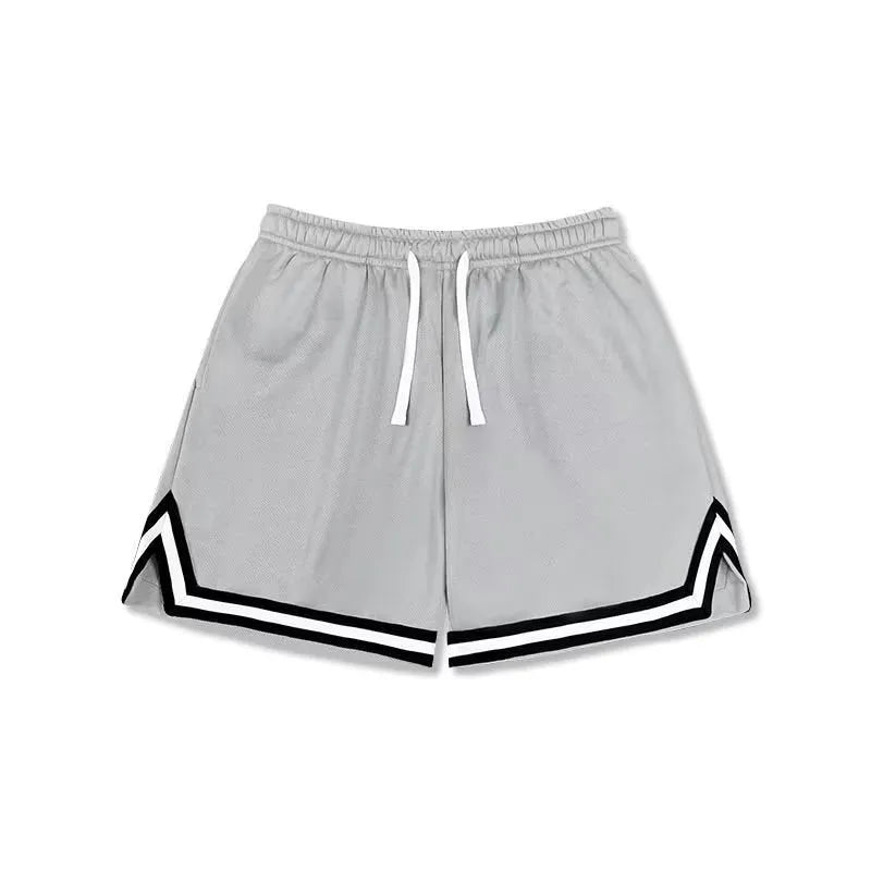 Man wearing loose grey sports shorts made from elastic polyester fabric.