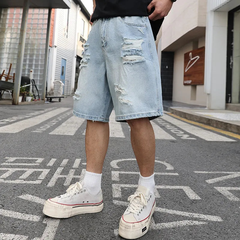 Light blue ripped denim shorts with a loose straight-leg fit on a mannequin.