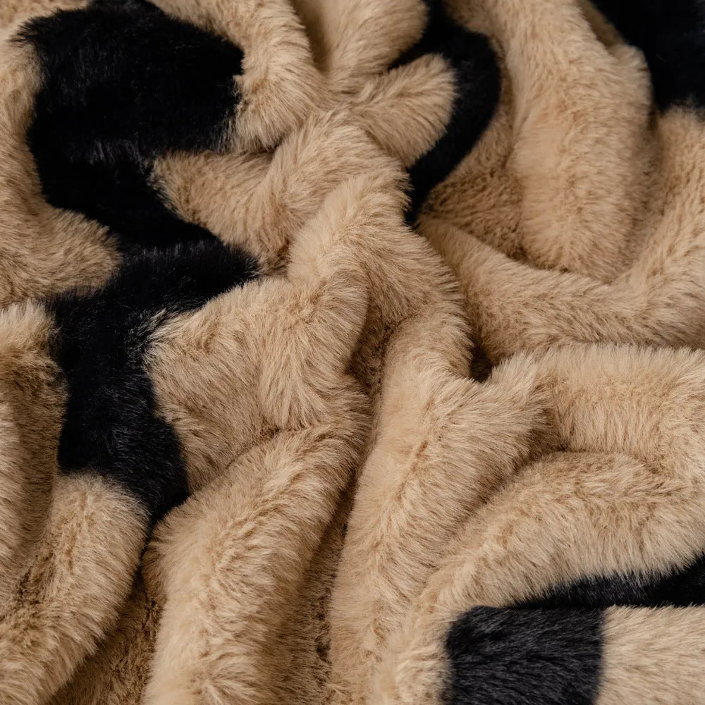 Thickened flannel zebra pattern sofa cover in caramel or black draping over a sofa with non-slip texture visible